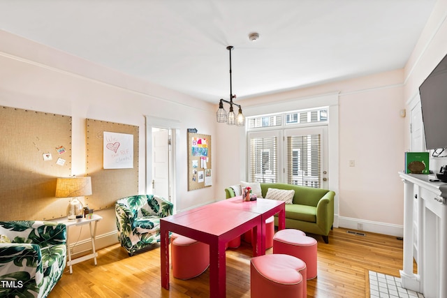 dining area featuring hardwood / wood-style flooring and a notable chandelier