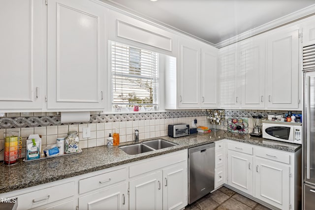 kitchen with sink, white cabinetry, dishwasher, dark stone counters, and decorative backsplash