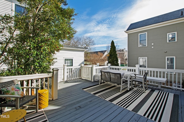 wooden terrace with an outdoor living space