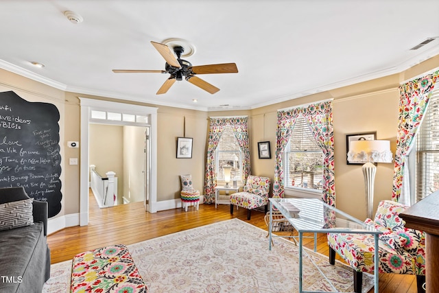 living room with crown molding, ceiling fan, and hardwood / wood-style floors