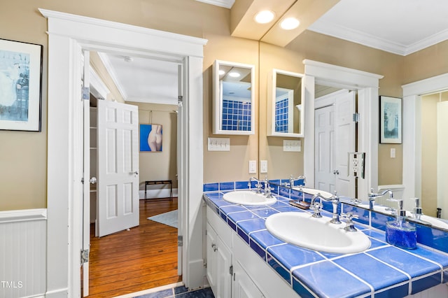 bathroom with hardwood / wood-style flooring, ornamental molding, and vanity