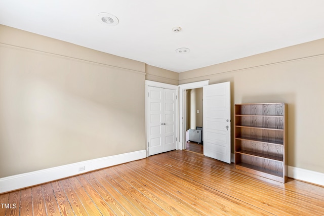 unfurnished bedroom with hardwood / wood-style flooring and a closet