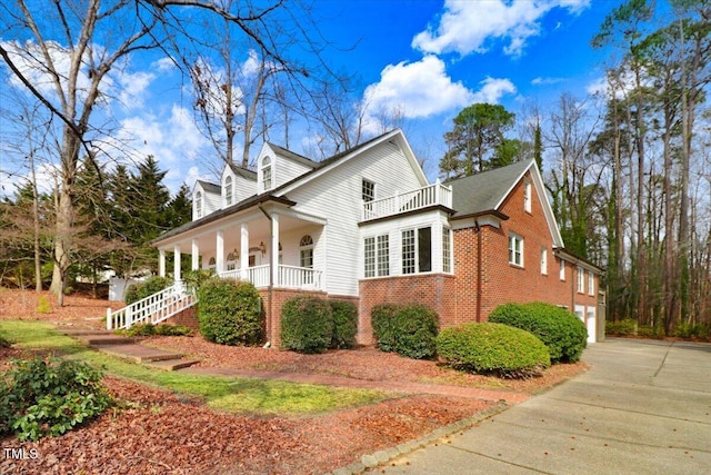 view of side of property with a garage and covered porch