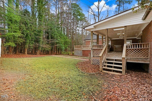 view of yard featuring ceiling fan and a deck