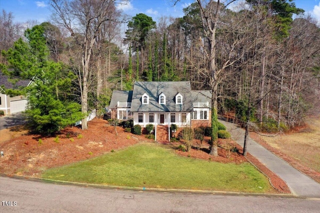 cape cod home featuring a front lawn