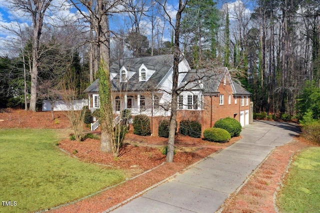 cape cod-style house featuring a garage and a front yard