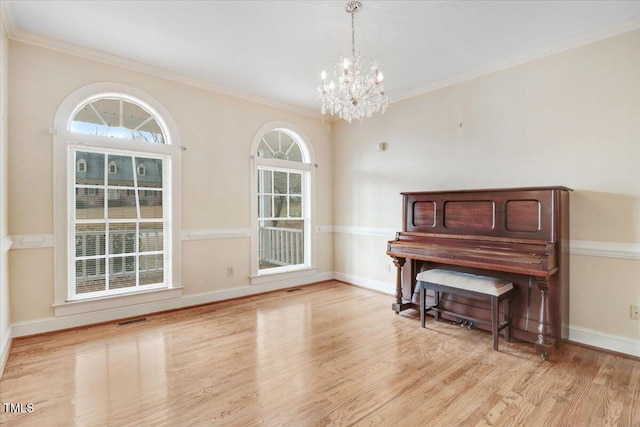 misc room with ornamental molding, a chandelier, and light hardwood / wood-style floors