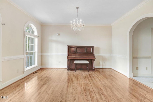 miscellaneous room with ornamental molding, a chandelier, and light wood-type flooring