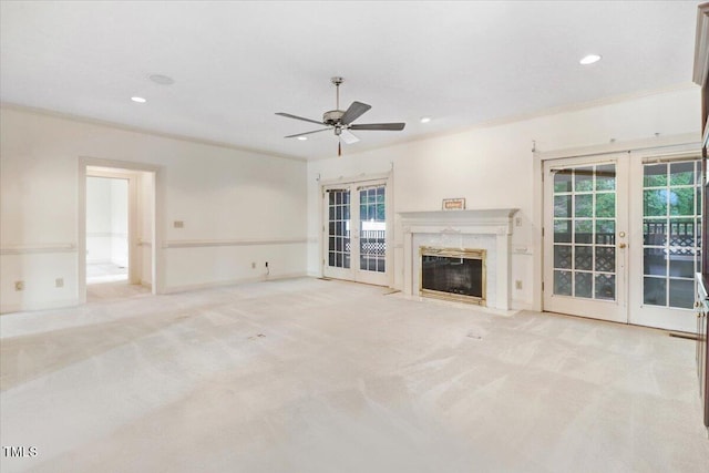 unfurnished living room featuring crown molding, light carpet, and french doors