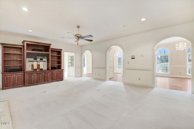 unfurnished living room with crown molding, light colored carpet, and ceiling fan