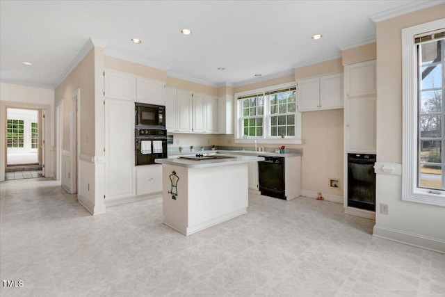 kitchen with white cabinetry, crown molding, a kitchen island, and black appliances