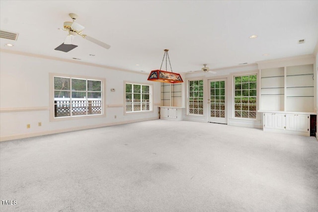 unfurnished living room with crown molding, ceiling fan, and carpet