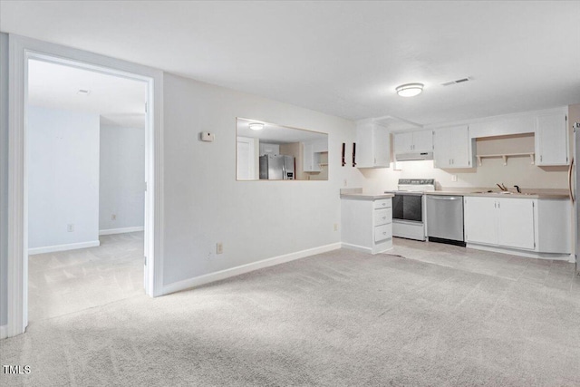 kitchen with stainless steel appliances, sink, light colored carpet, and white cabinets