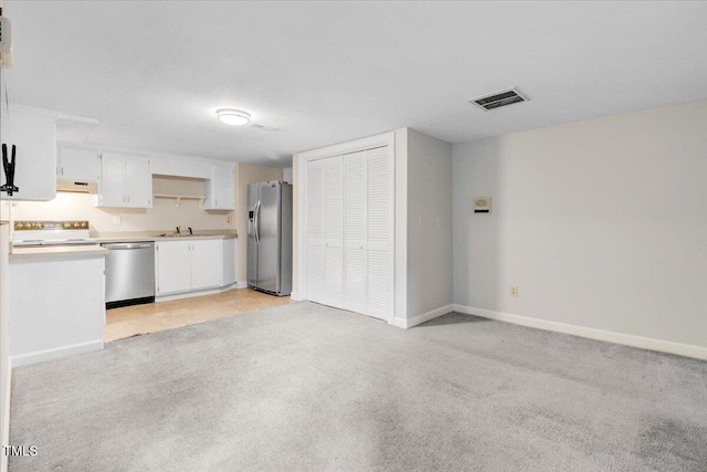 kitchen featuring white cabinetry, sink, light colored carpet, and appliances with stainless steel finishes