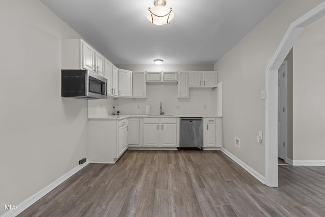 kitchen featuring appliances with stainless steel finishes, white cabinets, light hardwood / wood-style floors, and decorative backsplash