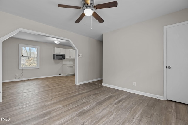 unfurnished living room featuring light hardwood / wood-style flooring and ceiling fan