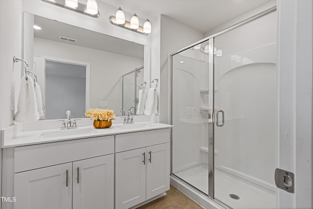 full bath featuring a shower stall, visible vents, and a sink