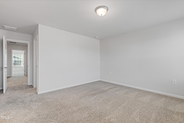 empty room featuring visible vents, baseboards, and carpet