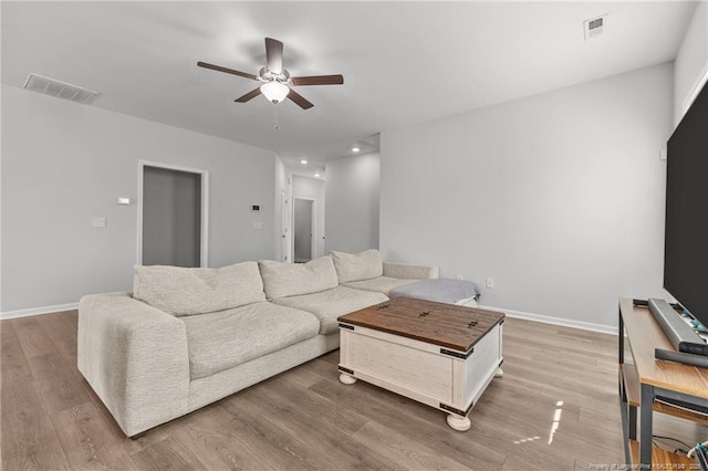 living room featuring wood-type flooring and ceiling fan