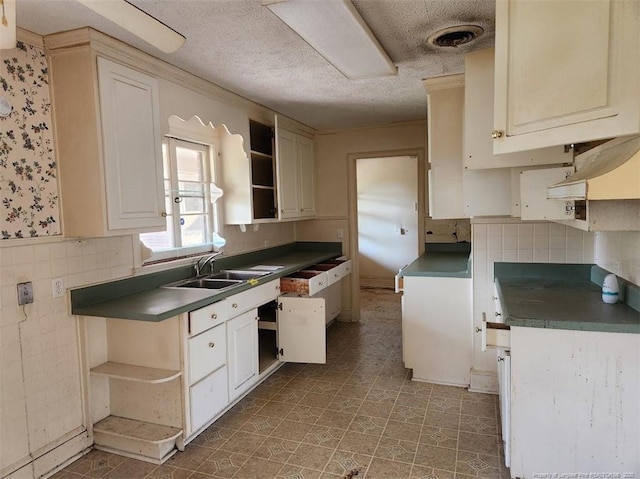 kitchen featuring sink, a textured ceiling, and decorative backsplash