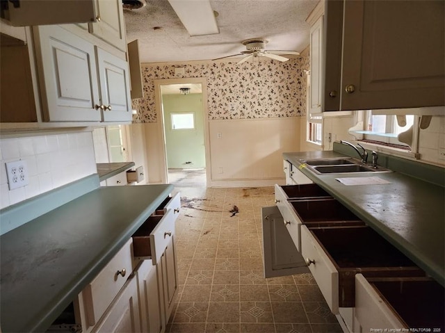 kitchen with ceiling fan, sink, and a textured ceiling