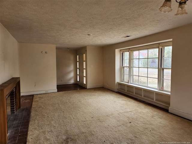 carpeted empty room featuring a baseboard heating unit and a textured ceiling