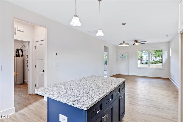 kitchen with water heater, hanging light fixtures, a center island, light hardwood / wood-style floors, and blue cabinetry