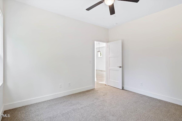 empty room featuring light colored carpet and ceiling fan