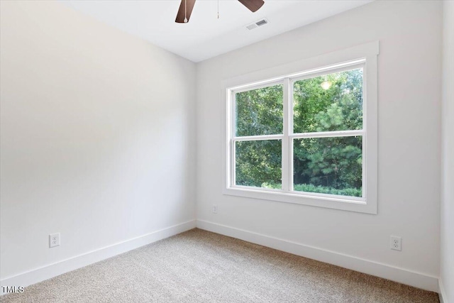 carpeted spare room with plenty of natural light and ceiling fan