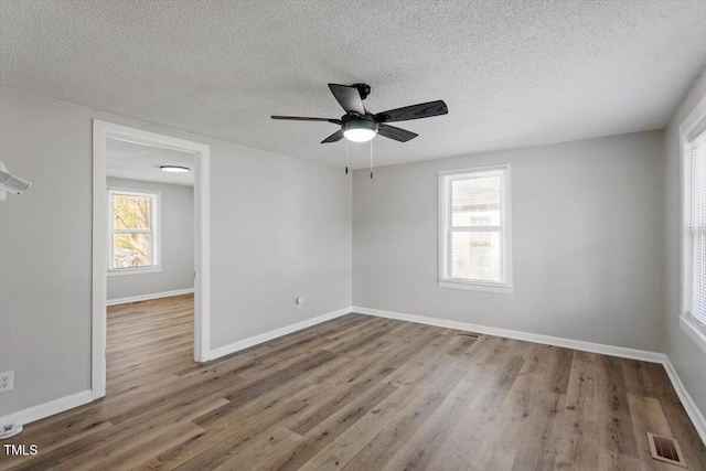 empty room with ceiling fan, hardwood / wood-style floors, and a textured ceiling