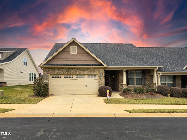 craftsman-style home featuring a garage and a lawn