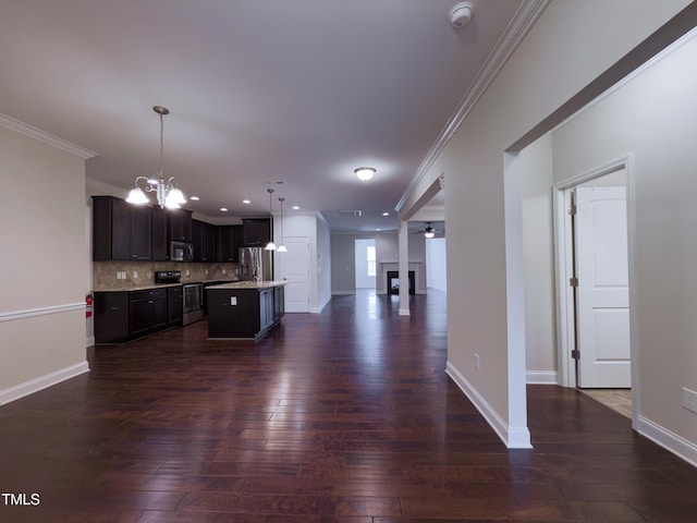 kitchen featuring dark brown cabinets, hanging light fixtures, appliances with stainless steel finishes, dark hardwood / wood-style flooring, and an island with sink