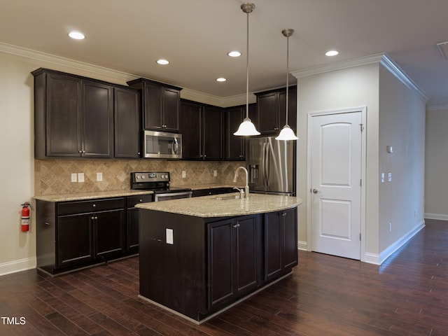 kitchen with sink, a center island with sink, appliances with stainless steel finishes, pendant lighting, and light stone countertops