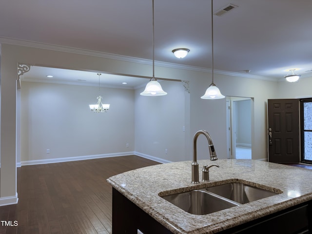 kitchen featuring pendant lighting, light stone countertops, and sink