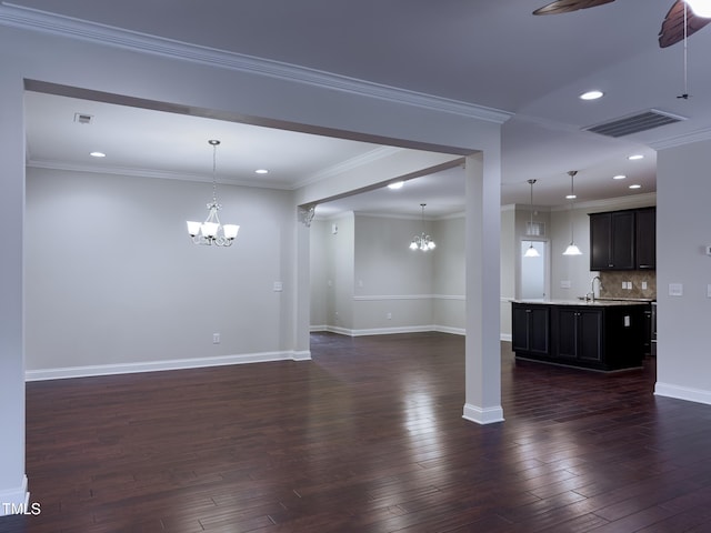 unfurnished living room with ceiling fan with notable chandelier, ornamental molding, dark hardwood / wood-style floors, and sink