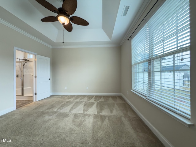 unfurnished bedroom featuring crown molding, a raised ceiling, and carpet flooring