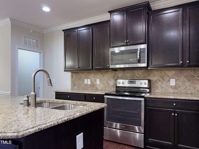 kitchen with appliances with stainless steel finishes, tasteful backsplash, sink, ornamental molding, and dark brown cabinetry