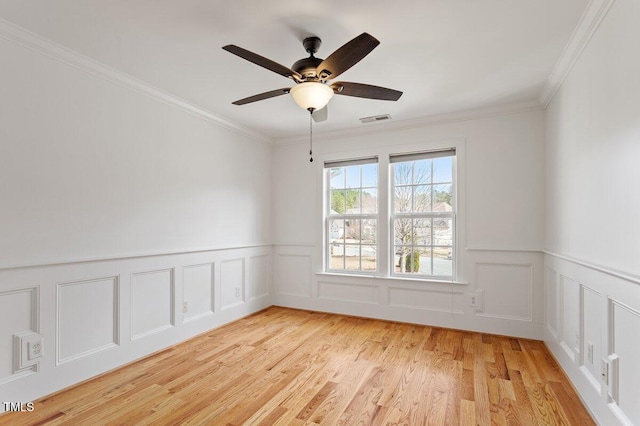 unfurnished room with light wood-type flooring, visible vents, crown molding, and ceiling fan