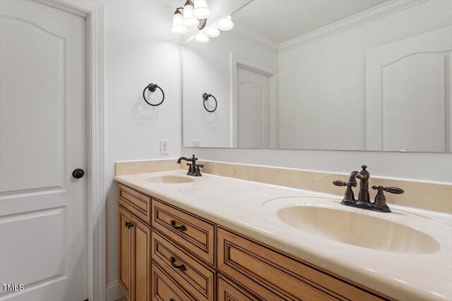 bathroom featuring double vanity, ornamental molding, and a sink