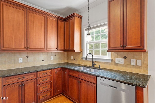 kitchen with decorative backsplash, dark stone counters, a sink, and stainless steel dishwasher