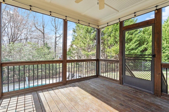 unfurnished sunroom featuring a ceiling fan