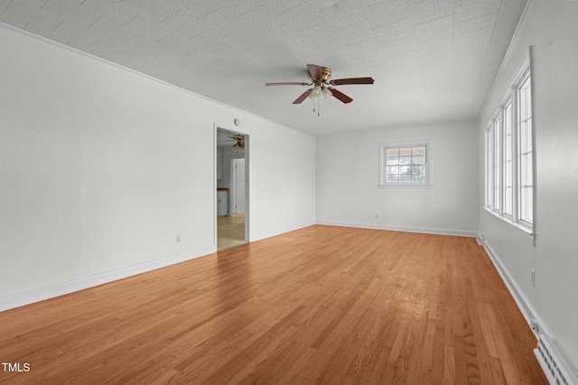 empty room with ceiling fan, a baseboard radiator, and light hardwood / wood-style floors