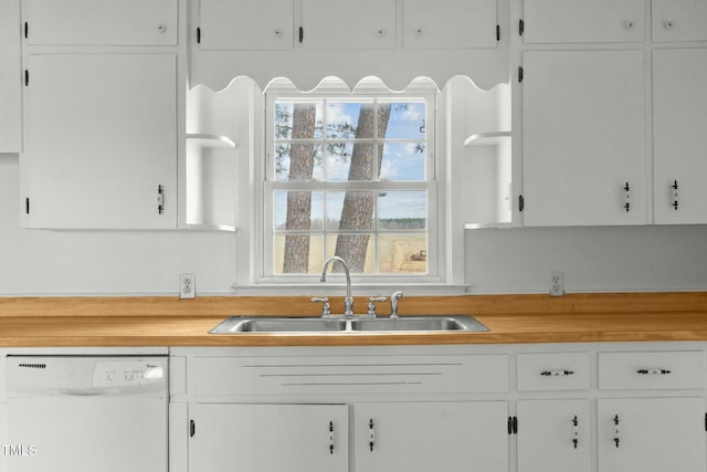 kitchen featuring white dishwasher, sink, and white cabinets