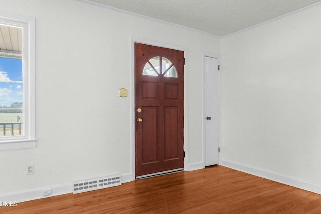 entrance foyer with wood-type flooring and ornamental molding