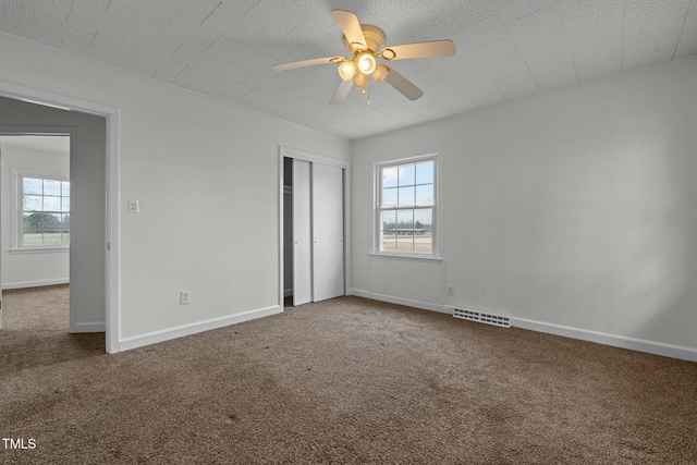 unfurnished bedroom featuring carpet floors, a textured ceiling, ceiling fan, and a closet