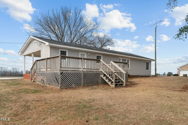 rear view of house with a wooden deck and a yard