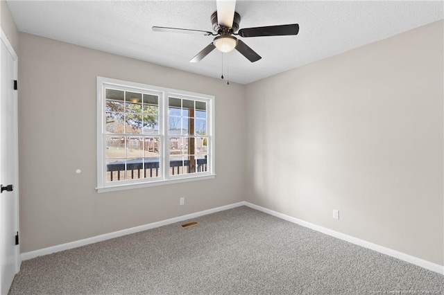 carpeted spare room with a textured ceiling and ceiling fan