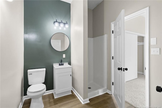 bathroom with vanity, hardwood / wood-style flooring, toilet, and a shower