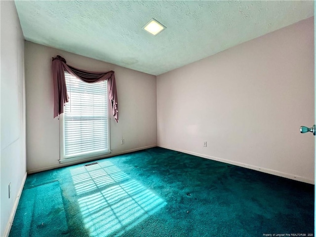 unfurnished room featuring dark colored carpet and a textured ceiling