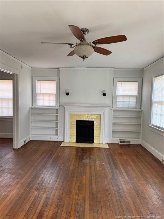 unfurnished living room featuring a brick fireplace and dark wood-type flooring